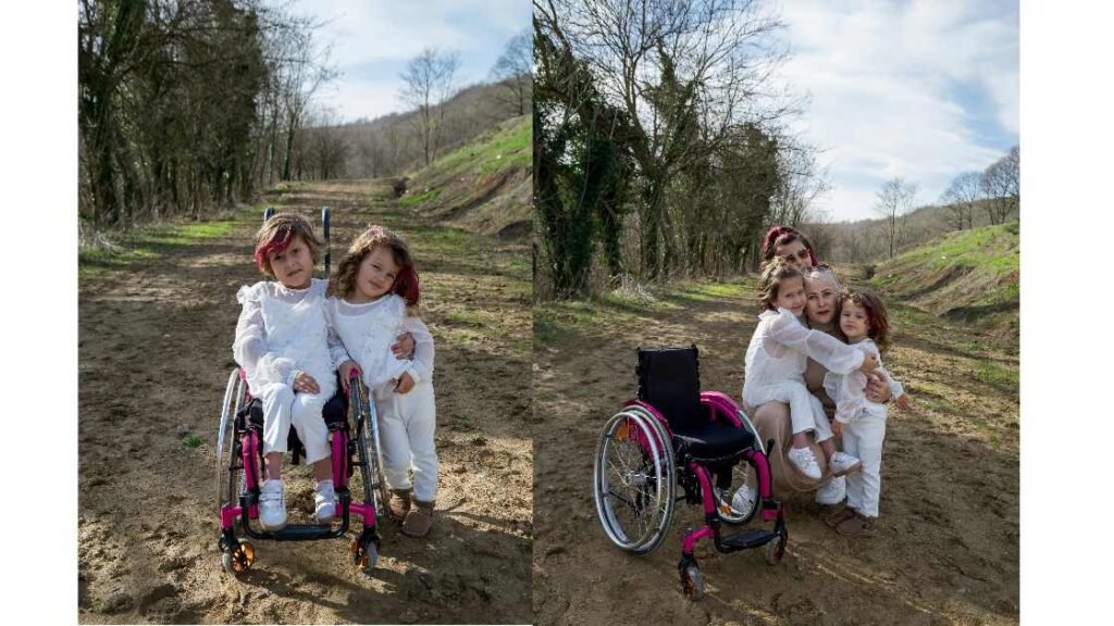 A Girl smiling in a Pediatric Wheelchair with his family